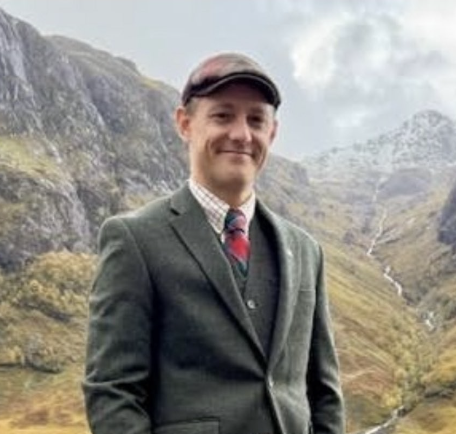 Tim smiling in a mountain landscape